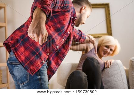 Angry man screaming, shouting and beating his wife at home. Couple man and woman having conflict about family life hile being at home.