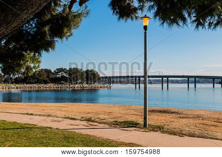 Lamppost at Vacation Isle Park with Mission Bay and Ingraham Street bridge in the background.