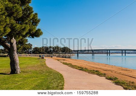 Path through Vacation Isle Park on Mission Bay in San Diego, with Ingraham Street bridge.