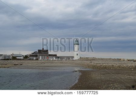 Beach rocks and Old Scituate Light in the harbor.
