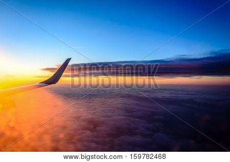 The view from the airplane at the clouds during sunset.