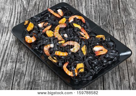 Black Noodles With Prawns And Mussels On Black Rectangular Platter