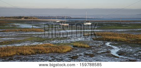Boats In Low Tide Mudflats Of Empty Harbour At Sunrise