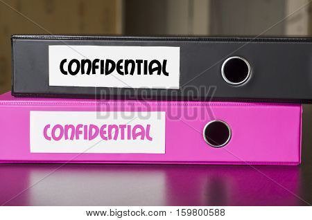 Bright office folders over dark background and confidential text concept