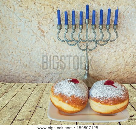 Jewish menorah and sweet donuts are traditional symbols for Hanukkah holiday