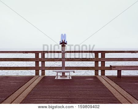 Seaside Telescope . Autumn Misty Morning On Wooden Pier Above Sea