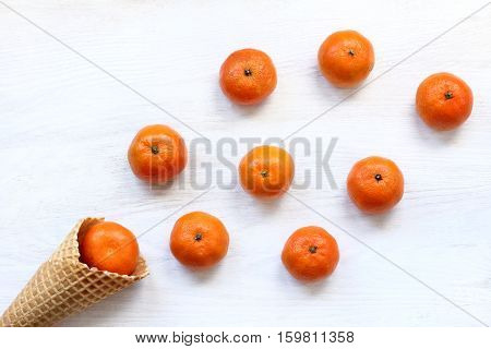 a lot of orange fruit spilled out on the table from the cone / tangerine extravaganza from the horn of plenty