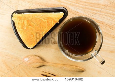Foi thong cake and a cup of coffee on wooden board