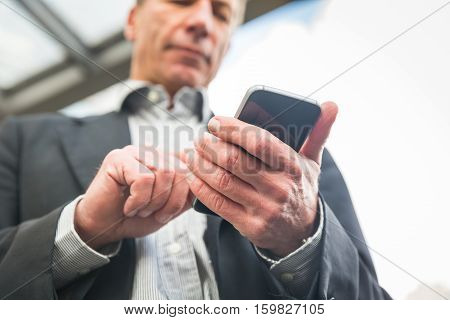 Businessman Looking And Typing On His Smart Phone