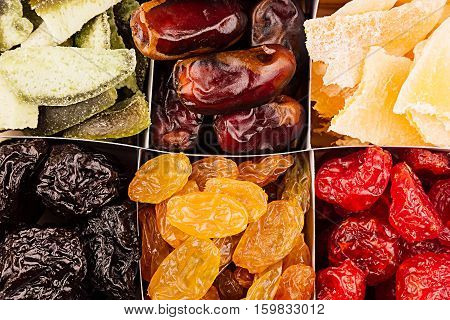 Assortment of dried fruits closeup background in square cells. Decorative pattern of dry exotic fruit. Top view.