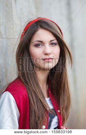 beautiful smiling teenager girl with piercing and make up listening music in headphones. Selective focus.