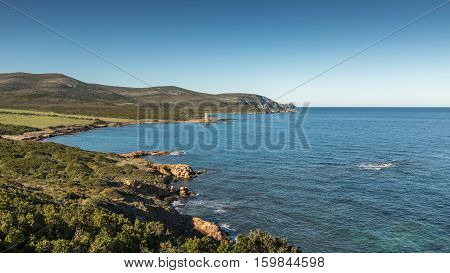 Genoese tower of Santa Maria della Chiappella at Rogliano on the east coast of Cap Corse in Corsica with the lighthouse on the Ile de la Giraglia in the distance on a clear blue sunny day
