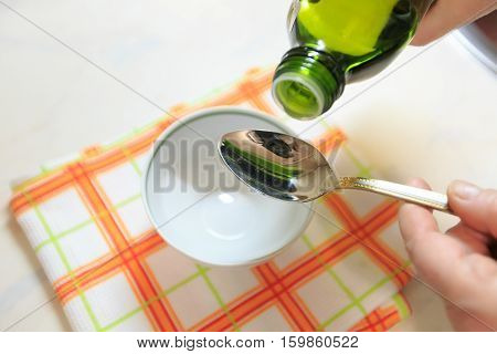 Olive oil on a teaspoon for background.