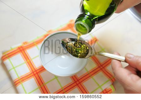 Olive oil on a teaspoon for background.