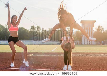 Fit women in the stadium playing leap frog
