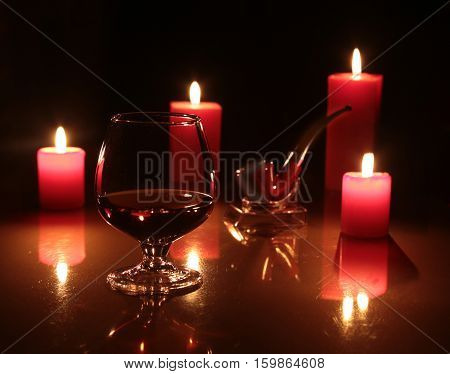 christmas composition photo cognac glass and candle on black background.