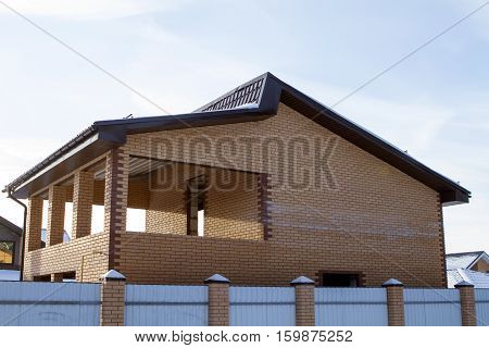unfinished brick private house against the sky. for metal wall corrugated board. without windows. winter