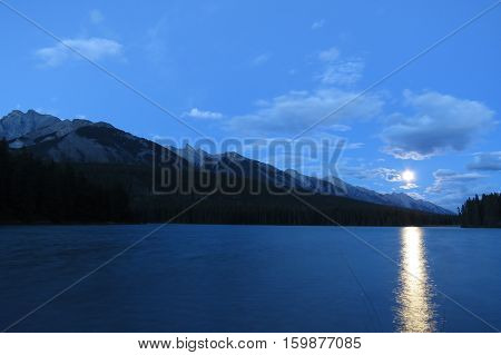 Long exposure: Bright moonrise above the mountains. Banff, Canada.