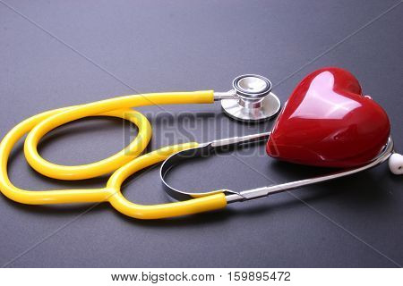 Red heart and a stethoscope on desc.