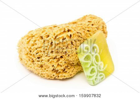 Natural yellow cleaning sponge with handmade soap bar over white background