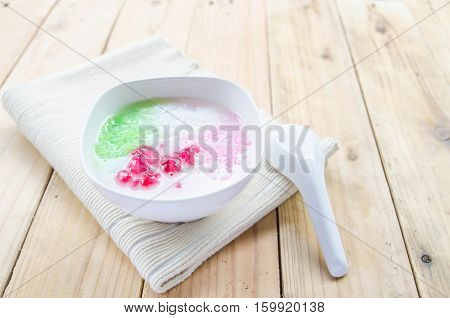 Tub Tim Krob ,Stuffed Water Chestnut in Syrup and Coconut Milk on wood table thailand dessert.