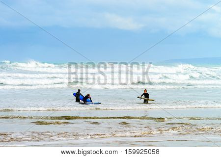 Adelaide Australia - August 14 2016: Female surfers with surfing boards entering the waters at Goolwa Beach