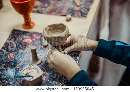 children's hands sculpts clay crafts pottery school
