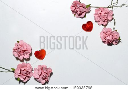 beautiful card for the holiday of love. Background for Valentine's Day. Postcard for weddings. Pink flowers on a white background scattered small hearts.