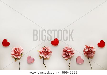 beautiful card for the holiday of love. Background for Valentine's Day. Postcard for weddings. Pink flowers on a white background scattered small hearts.