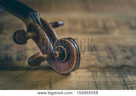 Tuning peg pegbox of old violin stringed musical instrument in close-up