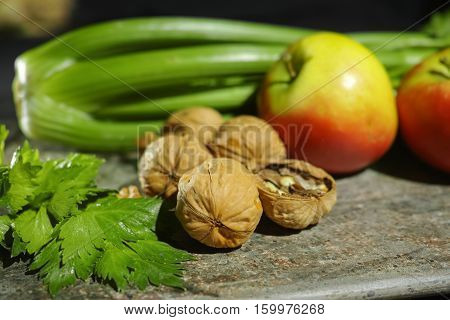 Ingredients for Waldorf salad - celery apples walnutes - fresh and healthy vegetables on granite board.