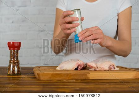Girl salt the chicken with sea salt