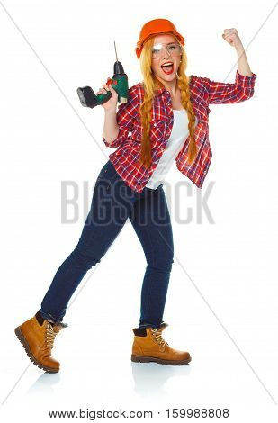 Female construction worker in a hard hat with a perforator