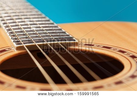 Classic fcoustic guitar on blue background upclose