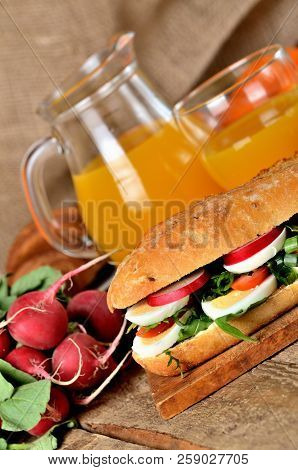 Baguette Sandwich With Egg, Arugula Salad, Tomatoes And Radish