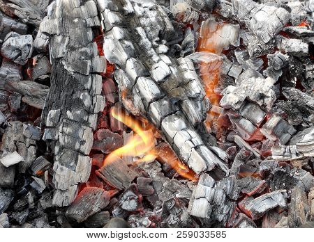 Beautiful Red Flame From Slice Wood, Dark Grey Black Coals Inside Metal Brazier. Wood Burning In The