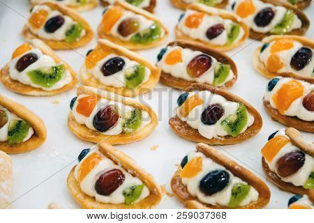 Cakes With Pieces Of Fruit Cream Are On A Baking Tray And Ready To Eat.