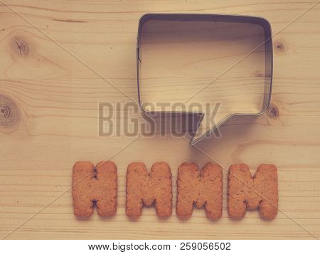 The Word Hmmm With A Speech Bubble On A Wooden Table