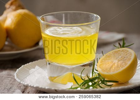 Ginger Tea With Lemon, Ginger Root And Rosemarry On Wooden Background. Small Glass Transparent Pitch
