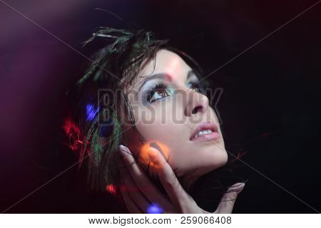 Portrait of a young girl with evening make-up and feather decora