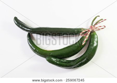 Three Curved Green Chilaca Peppers Tied With Red Hemp Twine Isolated On White, Horizontal Aspect