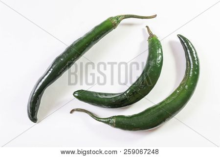 Top Angled View Of Three Green Chilaca Peppers Isolated On White, Horizontal Aspect