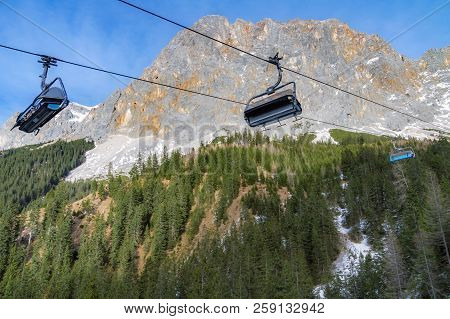 Alpine Scenery With The Rocky Peaks Of The Alps Mountains And Ski Lifts Rolling On A Cableway Over T