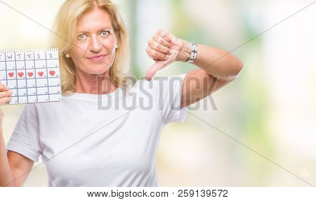 Middle age blonde woman holding menstruation calendar ver isolated background with angry face 