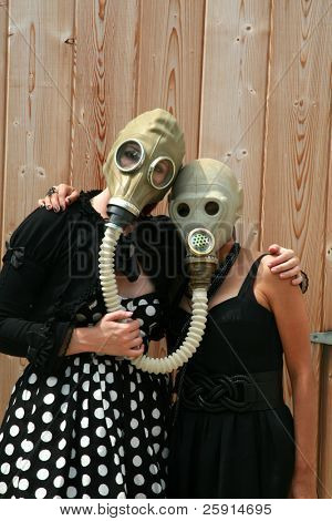 duas mulheres jovens usam máscaras de gás ligadas uns aos outros para uma fotografia uniqe