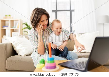 multi-tasking, freelance and motherhood concept - working mother with baby son calling on smartphone at home