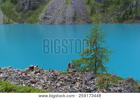 Pyramids Of Stones, Made By Tourists On The Shore Of The Large (lower) Shavlinsky Lake. Altai Mounta