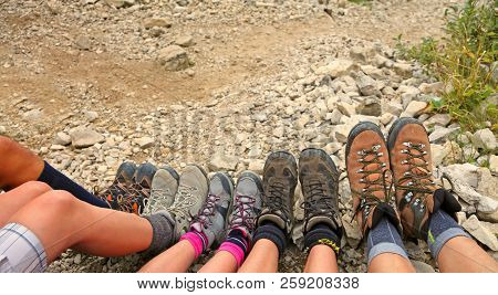 Ten Hiking Boots Of A Family Of Five Persons In Mountain