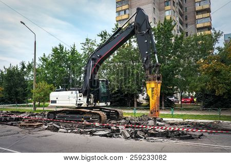 Excavator Breaking Concrete Road Surface With Hydrohammer Drill At Repairing Roadwork. Overhaul Of T