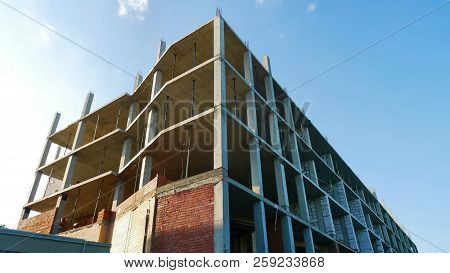 Construction Site Background. Building Under Construction Against Blue Sky.